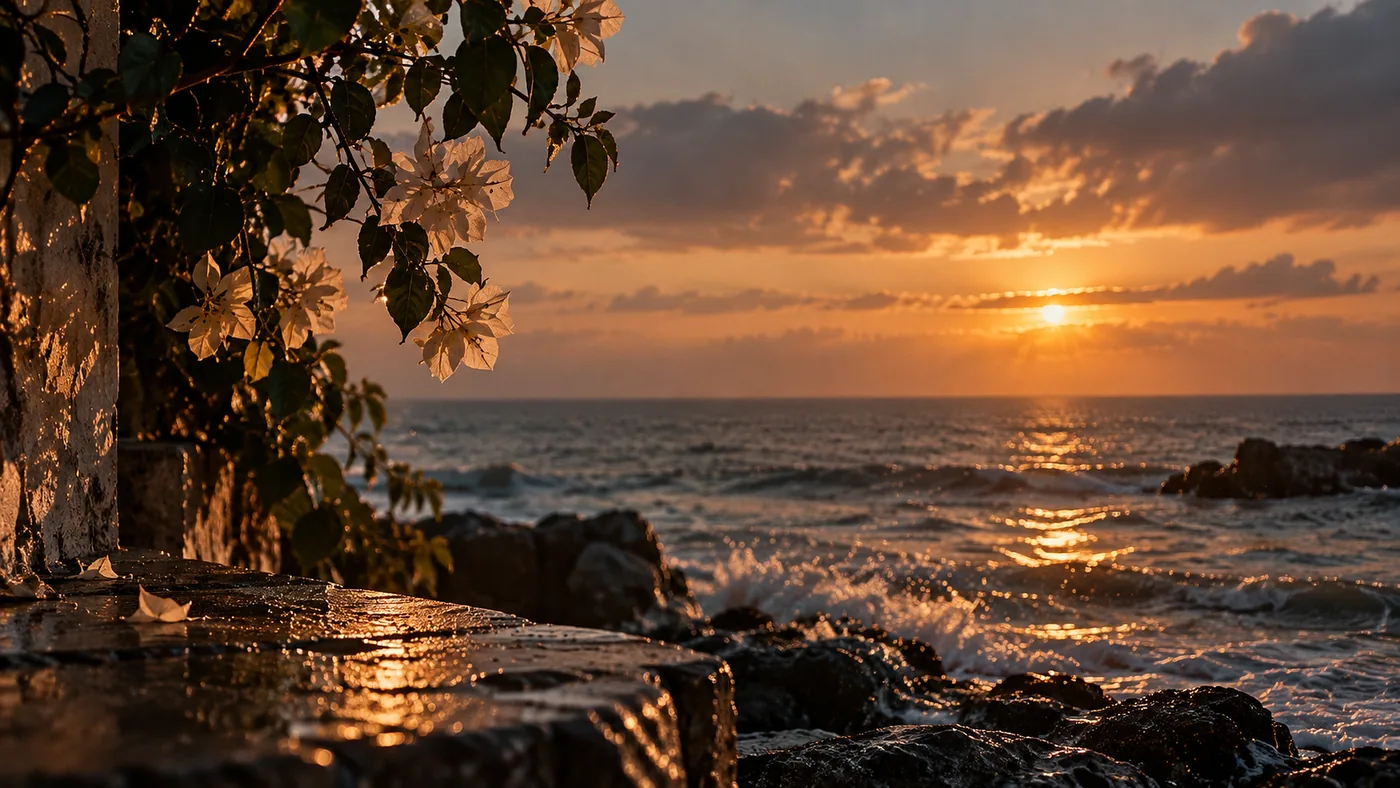 Sunset over the sea, waves breaking on dark rocks